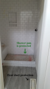 Tile being installed in boys' shower. Shower pan is protected