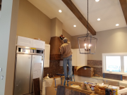 Paul installing reclaimed lumber panels at range hood