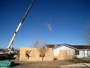 Roof trusses are being lifted into position by crane operator