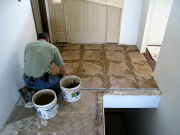 Don working on tile by entry
