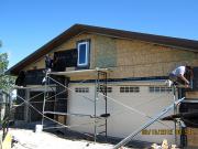 Stucco crew working on garage wall