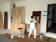 Painter applying stain on doors