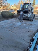 Breaking concrete in existing driveway with hydraulic hammer