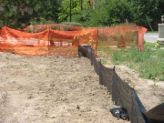 Silt fence for drainage control & orange fence is protection for water quality pond area