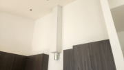 Range hood chase installed on tall kitchen wall