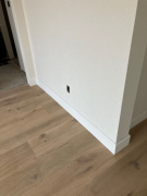 Baseboards on hardwood in primary bedroom