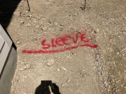 Sleeve location under sidewalk is marked